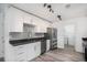 Modern kitchen with white cabinets, gray backsplash, stainless steel appliances, and wood-look flooring at 19153 E 51St Ave, Denver, CO 80249
