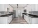 Modern kitchen featuring stainless steel appliances, subway tile backsplash, dark countertops, and wood floor at 19153 E 51St Ave, Denver, CO 80249