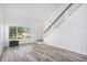 Bright living room with wood-look floors, staircase with glass railing, large window, and fish tank at 19153 E 51St Ave, Denver, CO 80249