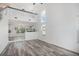 Open-concept living area with high ceilings, modern staircase, wood-look floors, and large windows at 19153 E 51St Ave, Denver, CO 80249