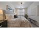 Serene bedroom with a plush bed, modern art, soft lighting, and a comfortable bench by a sunny window at 1841 S Dunkirk St # 203, Aurora, CO 80017