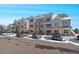 Modern apartment building with ample parking and snow-covered landscape at 1841 S Dunkirk St # 203, Aurora, CO 80017