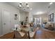 Bright, open-concept living room with glass dining table, modern lighting, and sliding glass doors to a balcony at 1841 S Dunkirk St # 203, Aurora, CO 80017