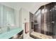 Stylish bathroom featuring a glass shower with dark tile, a vanity with a vessel sink, and modern fixtures at 2530 N Franklin St, Denver, CO 80205