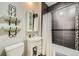 Cozy bathroom with dark tile, a bathtub, and a vanity with a white sink with plenty of towel racks at 2530 N Franklin St, Denver, CO 80205