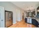 Open kitchen with stainless steel refrigerator, hardwood floors, and modern finishes at 2530 N Franklin St, Denver, CO 80205
