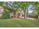 Large backyard features a wood deck, brick patio, mature trees, and grass at 18984 E Kent Cir, Aurora, CO 80013