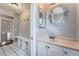 Hallway bathroom features white cabinetry, decorative mirror, and tile flooring at 18984 E Kent Cir, Aurora, CO 80013