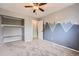 Carpeted bedroom features gray walls, mountain mural, ceiling fan, and an open closet at 18984 E Kent Cir, Aurora, CO 80013