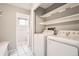 Laundry room features a washer and dryer, tile floors, and storage shelves at 18984 E Kent Cir, Aurora, CO 80013