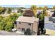 Back exterior of the home, surrounded by mature trees and grass, near a patio and a fence at 6898 W Rockland Pl, Littleton, CO 80128