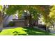 Landscaped front yard of a charming home with mature trees offering shade and curb appeal at 6898 W Rockland Pl, Littleton, CO 80128