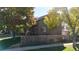 Charming house exterior surrounded by mature trees, grass and a wooden fence at 6898 W Rockland Pl, Littleton, CO 80128
