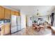 Open layout of the kitchen flowing into dining and living room with stainless steel refrigerator at 6898 W Rockland Pl, Littleton, CO 80128