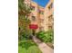 Charming apartment building entrance with red awning and mature landscaping at 1100 Colorado Blvd # 305, Denver, CO 80206