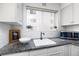 Clean kitchen featuring white cabinetry, tiled backsplash, and a stainless steel microwave at 1100 Colorado Blvd # 305, Denver, CO 80206