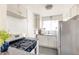 Compact kitchen includes gas range, stainless steel refrigerator, and white cabinetry at 1100 Colorado Blvd # 305, Denver, CO 80206