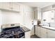 Well-maintained kitchen with gas range, white cabinets, and granite countertops at 1100 Colorado Blvd # 305, Denver, CO 80206