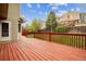 Inviting back deck with a red stain and view of a grassy, fenced yard at 5174 S Ukraine St, Aurora, CO 80015