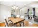 Bright dining room features hardwood floors, rustic wood table and seating for four, adjacent to the living room and kitchen at 5174 S Ukraine St, Aurora, CO 80015