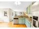 Charming kitchen features granite counters, wood floors, stainless appliances, and a view into the backyard deck at 5174 S Ukraine St, Aurora, CO 80015
