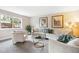 Cozy living room features neutral decor, plush carpet, and plenty of natural light from a large picture window at 5174 S Ukraine St, Aurora, CO 80015