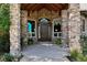 Covered entryway with stone columns and wood beams at 4479 Tierra Alta Dr, Castle Rock, CO 80104