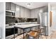 Modern kitchen features gray cabinets, stainless steel appliances, a black backsplash, and marble island with seating at 1200 Vine St # 5G, Denver, CO 80206