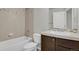 Bathroom with tiled shower over tub, vanity, toilet and mirror at 1775 Aspen Meadows Cir, Denver, CO 80260