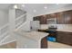 Stylish kitchen featuring stainless steel appliances, granite counters, and bar seating with a staircase view at 1775 Aspen Meadows Cir, Denver, CO 80260