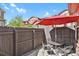 Private patio with an umbrella, surrounded by a wood fence at 1775 Aspen Meadows Cir, Denver, CO 80260