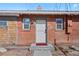 A classic red brick home is showcased, featuring a charming front door and meticulously kept landscaping at 3835 N Raleigh St, Denver, CO 80212