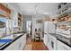 Cozy kitchen featuring stainless steel appliances, open shelving and white cabinets with black countertops at 3835 N Raleigh St, Denver, CO 80212