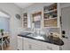 A kitchen featuring white cabinetry, modern fixtures, and open shelving near a bright dining area at 3835 N Raleigh St, Denver, CO 80212