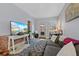 Inviting living room with a large TV, gray couch, tufted ottoman, and modern decor at 3835 N Raleigh St, Denver, CO 80212