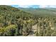 Beautiful mountain view with a winding road, lush forest, and blue skies at 25728 Stanley Park Rd, Evergreen, CO 80439