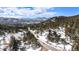 Scenic aerial view of a mountain road leading to a property nestled among evergreen trees at 25728 Stanley Park Rd, Evergreen, CO 80439