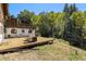 A spacious wooden deck with outdoor seating overlooks the lush backyard and green trees at 25728 Stanley Park Rd, Evergreen, CO 80439