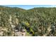 Beautiful home with mountain views covered in snow on a sunny day at 25728 Stanley Park Rd, Evergreen, CO 80439