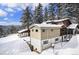 Charming mountain home exterior surrounded by snow-covered trees and beautiful landscape at 25728 Stanley Park Rd, Evergreen, CO 80439