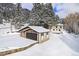 Exterior of a home with a two-car garage and lots of beautiful evergreen trees at 25728 Stanley Park Rd, Evergreen, CO 80439