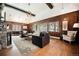 Inviting living room featuring hardwood floors, a stone fireplace, and paneled walls at 25728 Stanley Park Rd, Evergreen, CO 80439