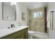 Modern bathroom with green vanity, tile shower, and updated fixtures at 12870 W Grand Pl, Morrison, CO 80465