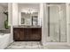 Elegant bathroom boasts a double vanity, large mirror, stylish lighting, a glass-enclosed shower, and a soaking tub at 2110 W 67Th Pl, Denver, CO 80221