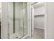 Modern bathroom with glass-enclosed shower featuring a built-in bench seat and direct access to the closet at 2110 W 67Th Pl, Denver, CO 80221