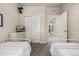 Bright bedroom featuring twin beds, neutral walls, closet, and a glimpse into the hallway at 2110 W 67Th Pl, Denver, CO 80221