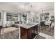 Open-concept kitchen flows into living and dining areas, features a granite island and modern fixtures at 2110 W 67Th Pl, Denver, CO 80221