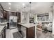 Bright kitchen with stainless appliances, granite island and view into the living room at 2110 W 67Th Pl, Denver, CO 80221