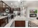 Modern kitchen boasts stainless appliances, dark wood cabinets, and a large granite island at 2110 W 67Th Pl, Denver, CO 80221