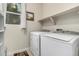 Laundry room features a window, washer, dryer, and shelving with room for storage at 2110 W 67Th Pl, Denver, CO 80221